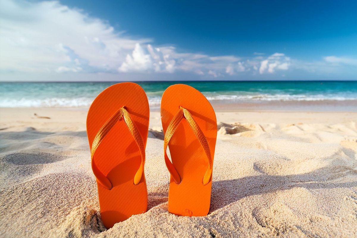 Flip-Flops in leuchtendem Orange am Strand