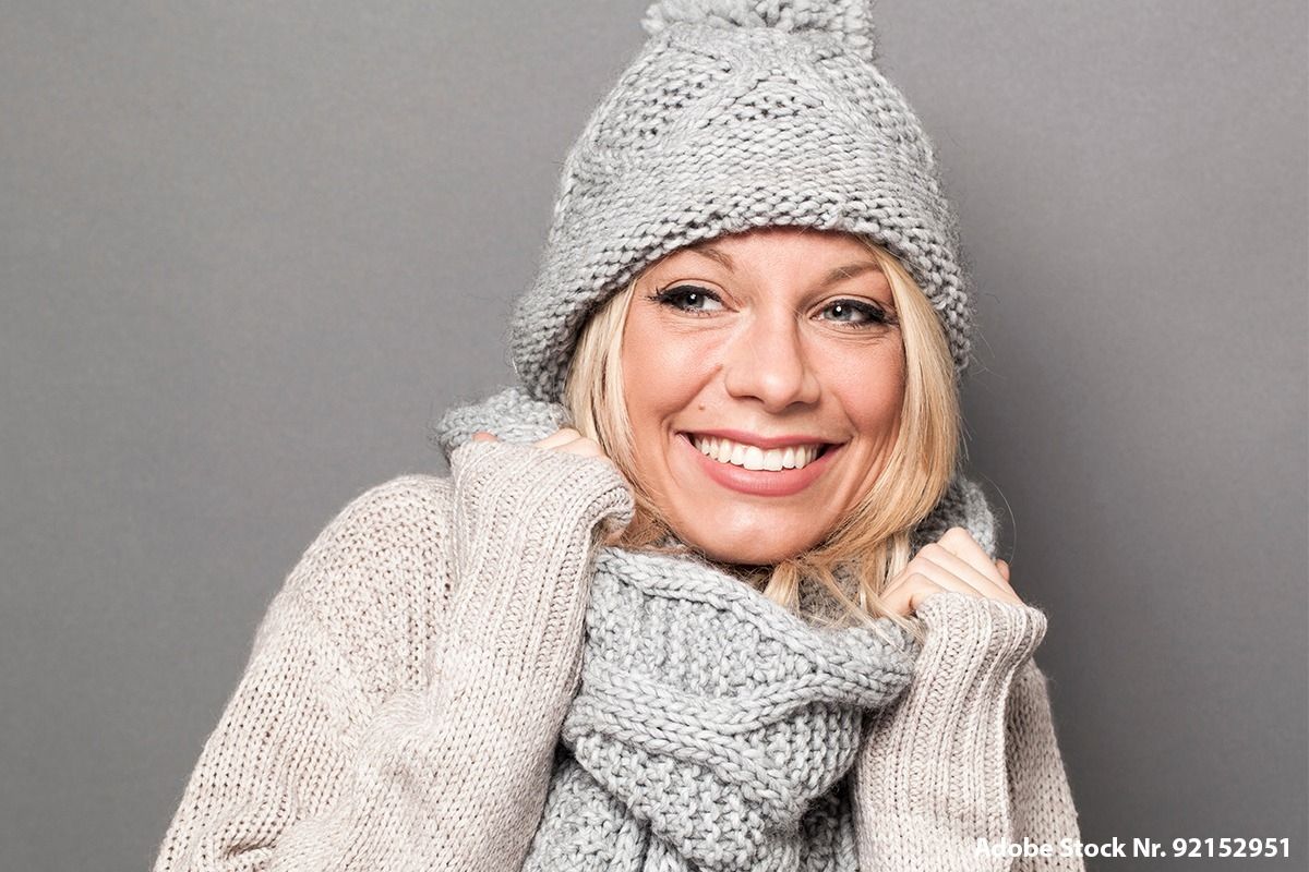 Frau ist eingekuschelt in warmen Wintersachen.