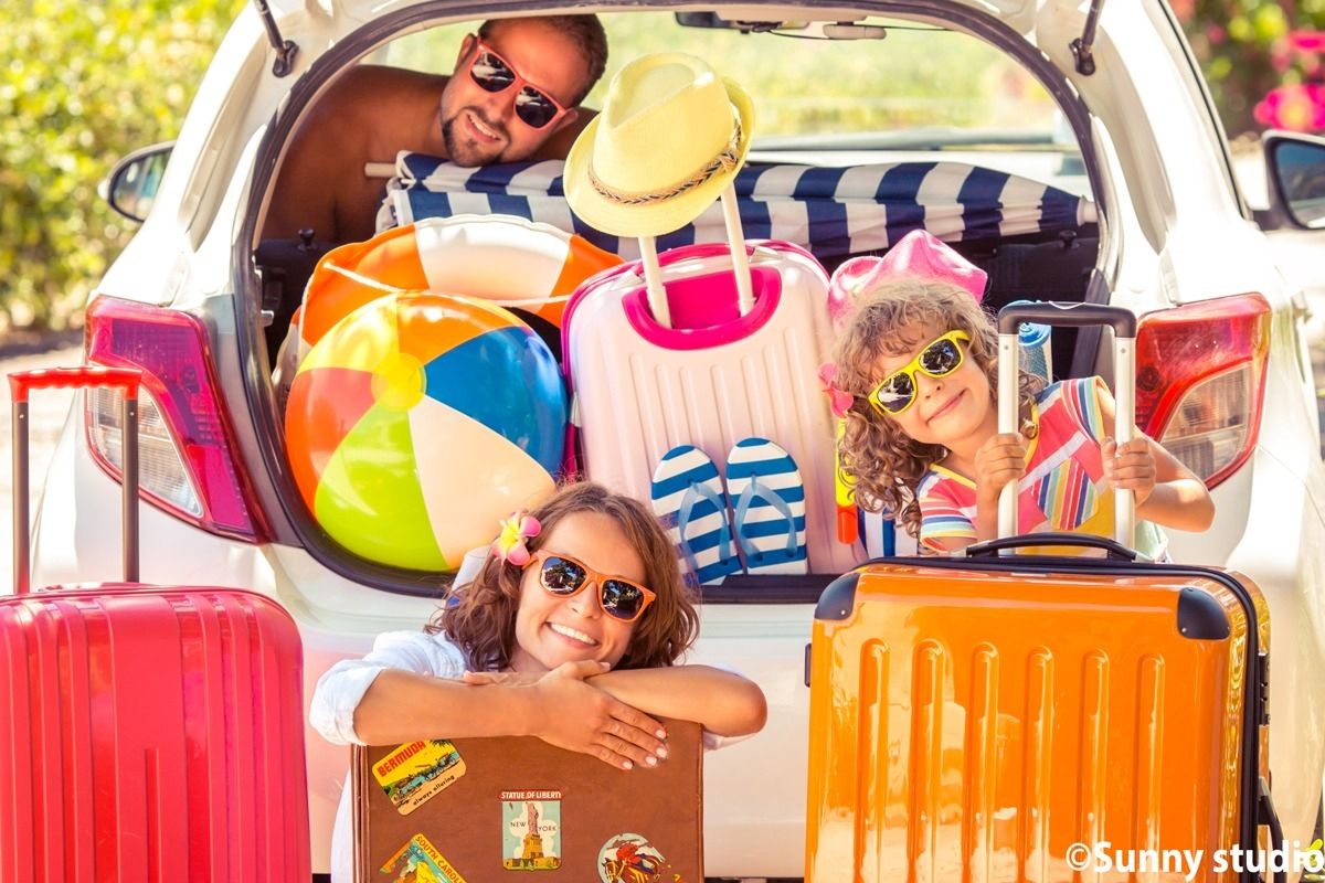 Familie mit vollgepacktem Auto, bereit für den Urlaub.
