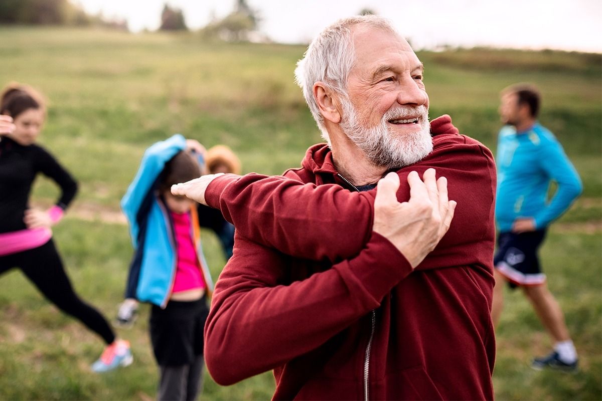 Gruppe von Leuten in Sportklamotten, die sich aufwärmen.