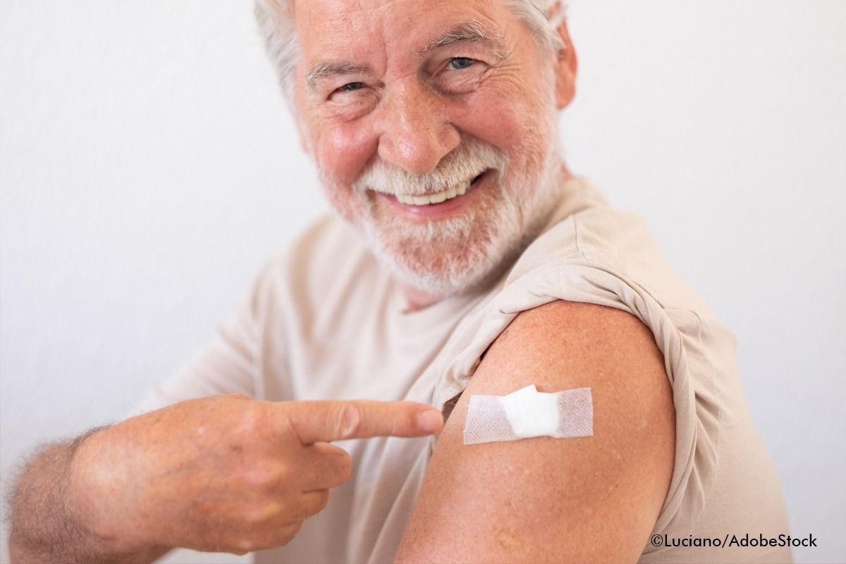 Älterer Mann zeigt auf seine frische Impfung.