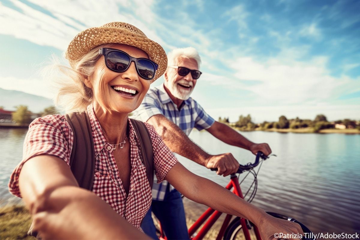 Älteres Pärchen sind mit dem Fahrrad unterwegs am See.