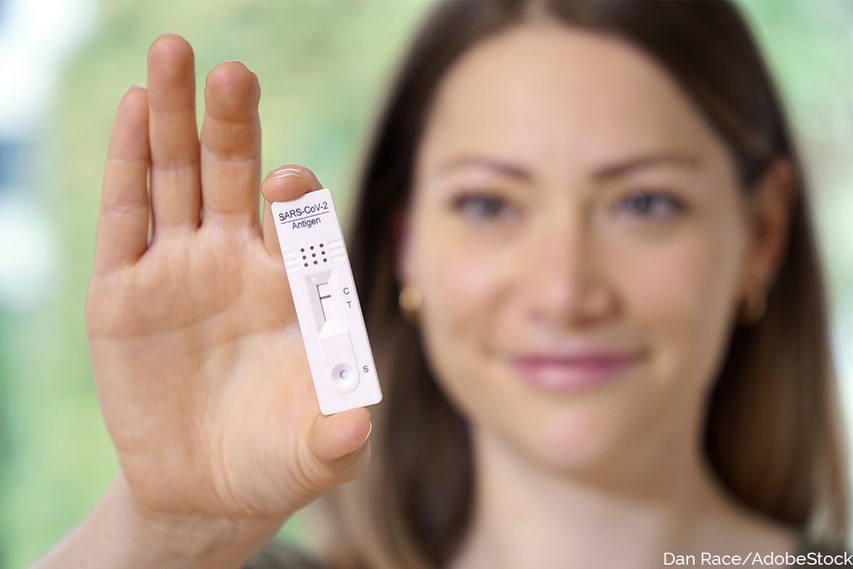 Frau hält einen Corona-Schnelltest hoch.