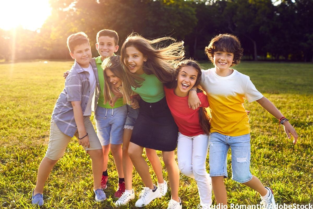 Sechs Kinder lachen zusammen.