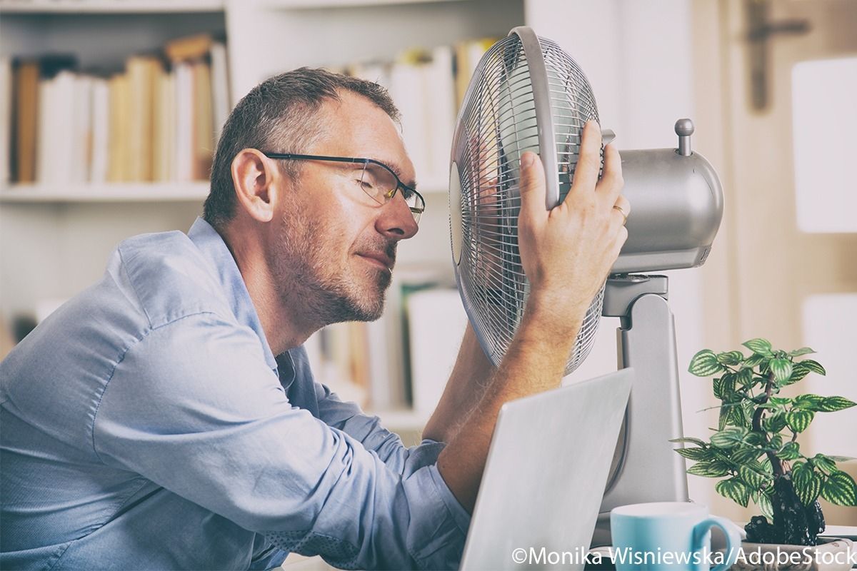 Man sitzt vor dem Ventilator und kühlt sich ab.