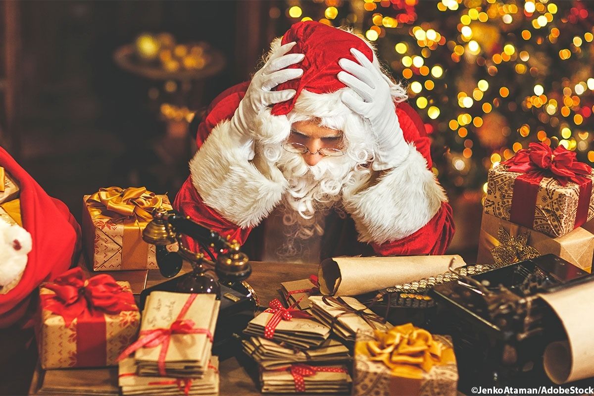 Ein gestresster Weihnachtsmann vor den Geschenken.