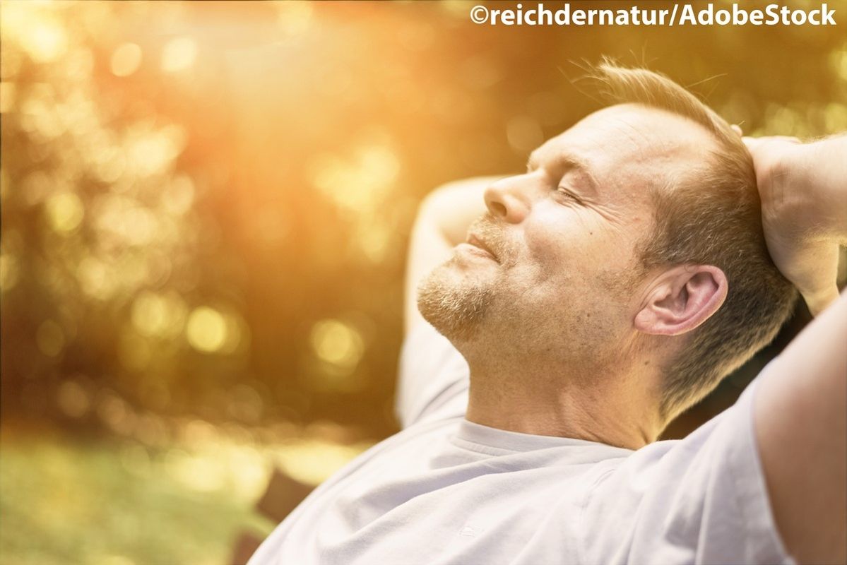 Ein entspannter Mann genießt die Sonne im Park.