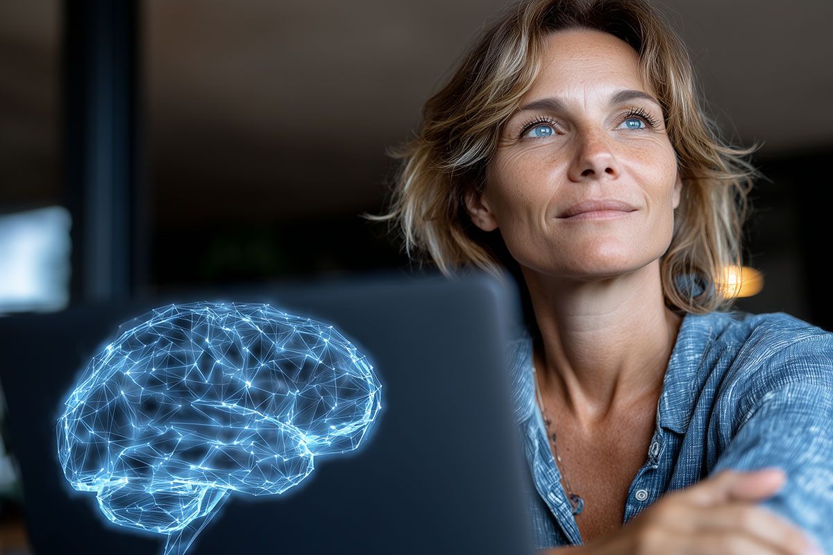 Frau, die nachdenklich auf einen Laptop mit einer digitalen Gehirnsimulation schaut.
