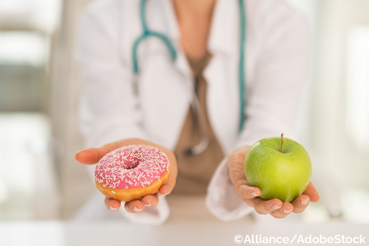 Ein Gesundheitsberater hält einen Donut und einen grünen Apfel in den Händen, um gesunde Ernährung zu symbolisieren.