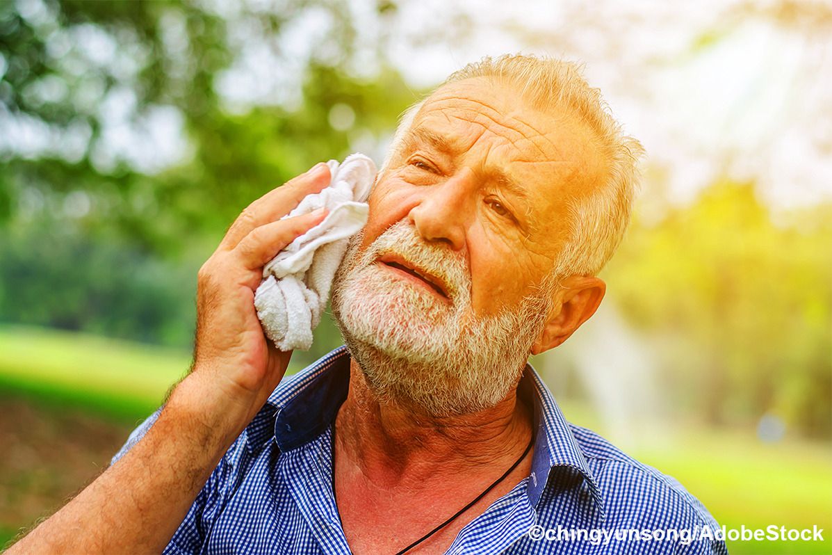 Ein älterer Mann wischt sich den Schweiß mit einem Handtuch ab.